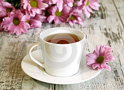 cup of tea and chrysanthemums on old wooden Stock Photo