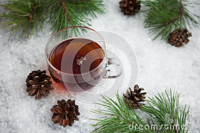 Cup of tea with cones on a snow backgroud Stock Photo