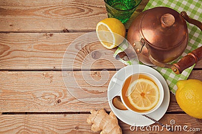 Cup of tea with ginger, lemon and tea pot on wooden table. View from above Stock Photo