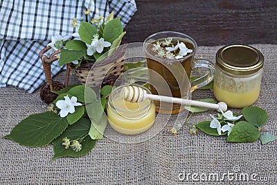 A cup of tea with linden and jasmine flowers and two jars of honey Stock Photo