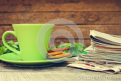 Cup of tea, mint, cookie, bunch of newspapers and magazines Stock Photo