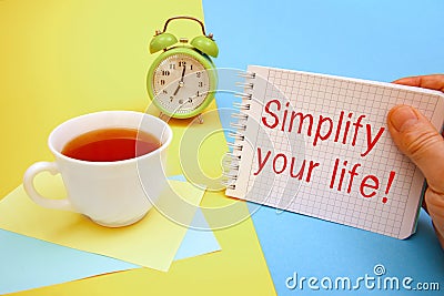 Cup of tea and a notebook with the inscription Simplify your life.Conceptual photo. Take the easy way Stock Photo