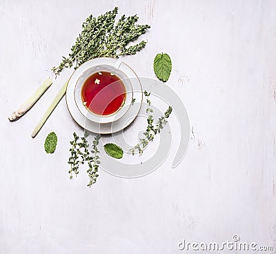 Cup of tea on a saucer with a set of herbal tea thyme, mint, lemon grass on wooden rustic background top view with text area, vint Stock Photo