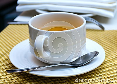 Cup of tea on saucer with a spoon Stock Photo