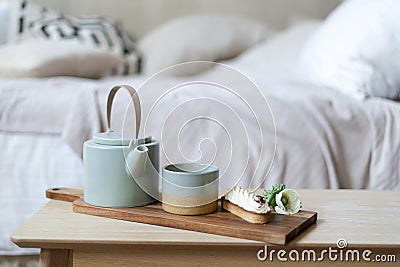 Cup of tea, teapot and eclair on serving tray Stock Photo