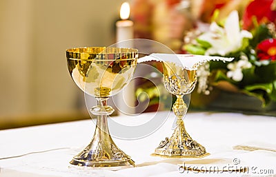 Cup with wine and ciborium with host on the altar of the holy mass Stock Photo