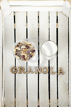Cup of yogurt, granola, a teaspoon and Granola inscription. Whit Stock Photo