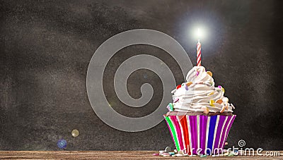 Cupcake with cream and candle with a blackboard background. Stock Photo