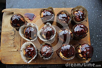 12 cupcakes in chocolate on a wooden board Stock Photo