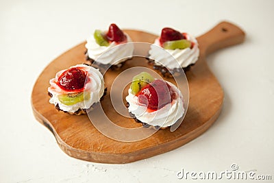 cupcakes with cottage cheese on vintage tray-tasty muffin with strawberry and kiwi on wooden plate Stock Photo