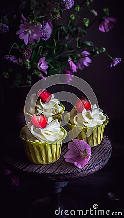 Cupcakes with strawberry on dark wooden table. Stock Photo