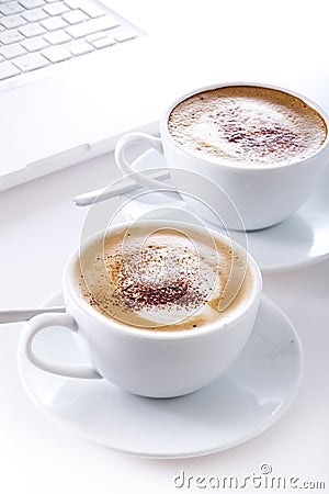 Cups of cappuccino with laptop Stock Photo