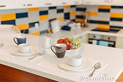 Cups, saucers and teaspoons on a white countertop in the kitchen. Stock Photo