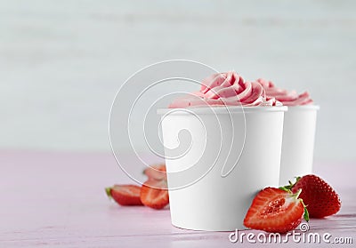 Cups with tasty frozen yogurt and strawberries on table. Space for text Stock Photo