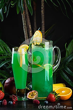 Curacao lemonade in a glass and jug decorated with an orange slice Stock Photo