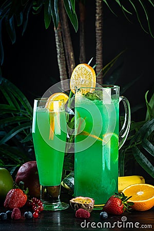 Curacao lemonade in a glass and jug decorated with an orange slice Stock Photo