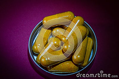 Curcumine capsules in container with a puple background Stock Photo