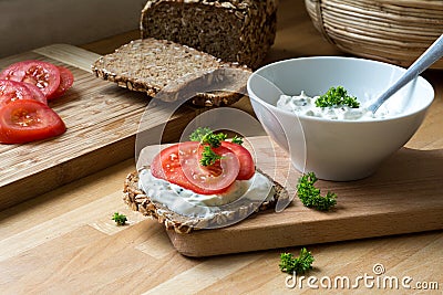 curd cheese dip with herbs and rustic wholegrain bread with tomatoes Stock Photo