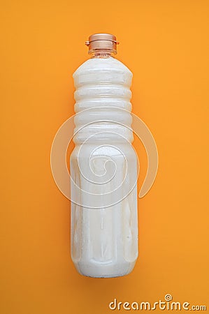 cured white coconut oil in a bottle on an orange background Stock Photo