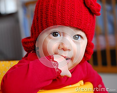 Curious baby girl with red cap Stock Photo