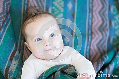 Curious baby in a warm green blanket Stock Photo