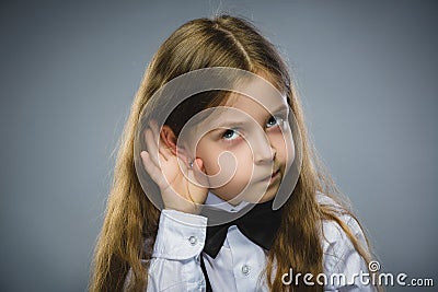 Curious Disappointed girl listens. Closeup portrait child hearing something, parents talk, hand to ear gesture isolated Stock Photo