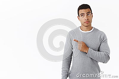 Curious handsome young hispanic man found something interesting, look intrigued pointing upper left corner, picking Stock Photo