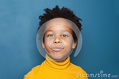 Curious kid portrait. Happy small black child on blue background Stock Photo