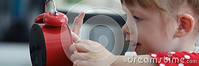 Curious little pretty girl explore red clock touch dial with finger Stock Photo