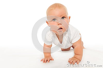 Curious looking baby crawls wearing white bodysuit Stock Photo