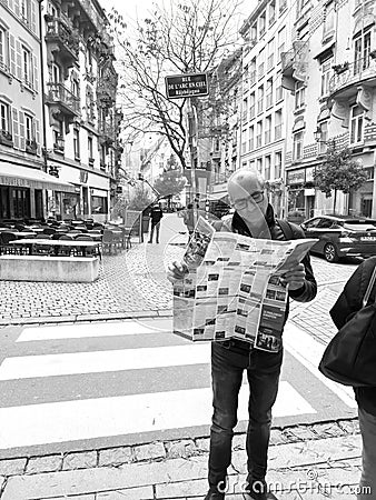 Curious male tourist reading a traveler tourist sightseeing map of Strasbourg in Editorial Stock Photo