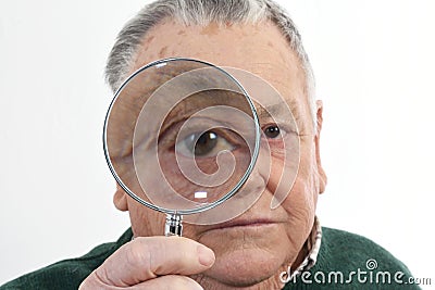 Curious man peering through magnifying glass Stock Photo