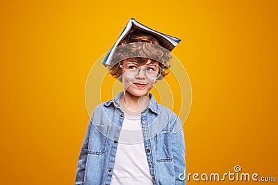 Curious pupil with textbook on head Stock Photo