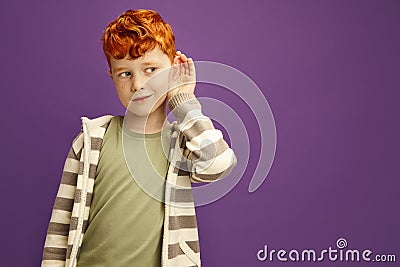 Curious Red Haired Boy Likes Gossips, Wants to Overhear Secret Information, is Overcoming by Curiosity, Tries to Hear Stock Photo