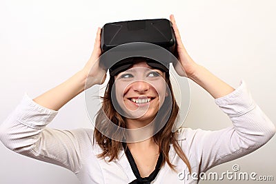 Curious, smiling woman in a white shirt, taking off or putting on Oculus Rift VR Virtual reality 3D headset Editorial Stock Photo