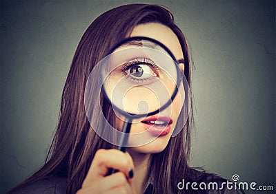 Curious woman looking through a magnifying glass Stock Photo