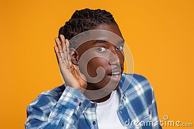 Curious Young Black Man Holding Hand Near Ear Trying To Overhear Something Stock Photo