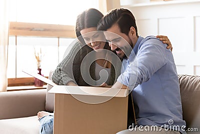 Curious young couple unpacking cardboard parcel package together Stock Photo