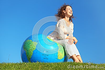 Curl woman sitting on inflatable globe Stock Photo