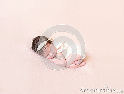 Curled up baby in knitted pastel costume Stock Photo