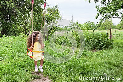Curly baby girl on swing Stock Photo
