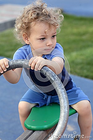 Curly child at seesaw Stock Photo