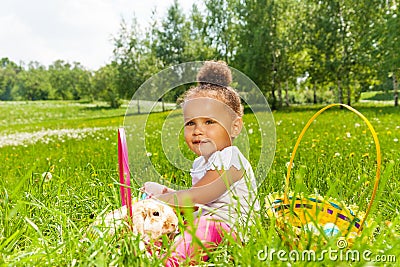 Curly cute girl with rabbit in green park Stock Photo