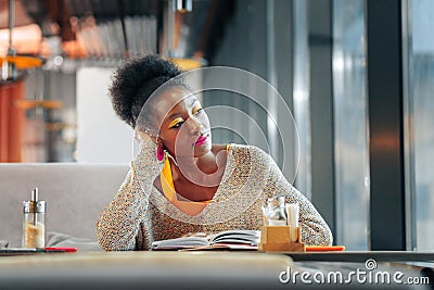 Curly dark-haired postgraduate student studying hard in cafeteria Stock Photo