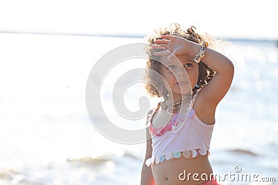 Curly girl pink dress with shell decorations on the beach Stock Photo