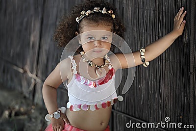 Curly girl in a pink dress with shell decorations on the nature Stock Photo