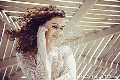 Curly girl smiling with happiness in a sunny alcove Stock Photo