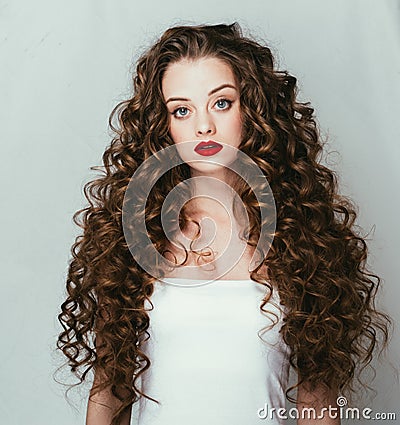 Curly hair woman portrait long hair with perfect make up red lips. Stock Photo