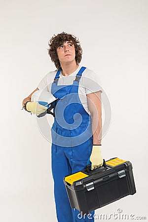 Construction, building and workers concept - Curly haired builder lifting up toolbox and white helmet in studio. Stock Photo