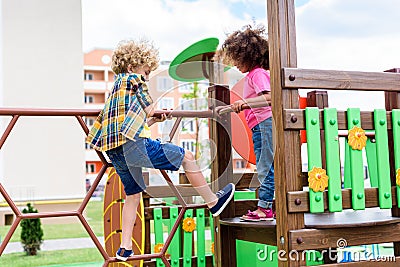 curly multiethnic little children climbing and having fun Stock Photo